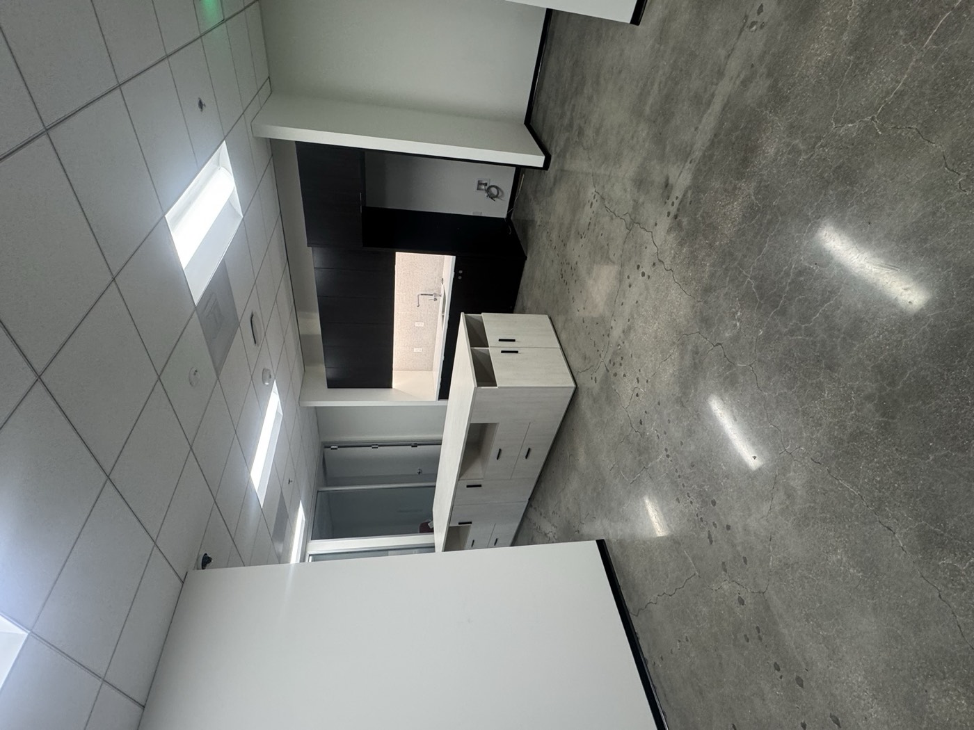 Finished office breakroom with custom millwork island and polished concrete flooring
